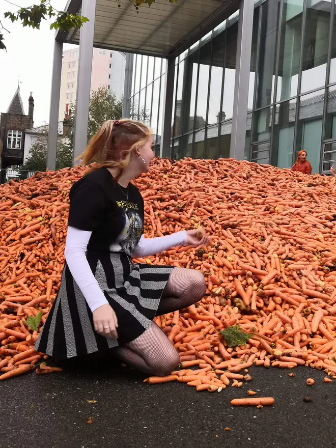 Some people took photos on top of or in front of the pile of carrots