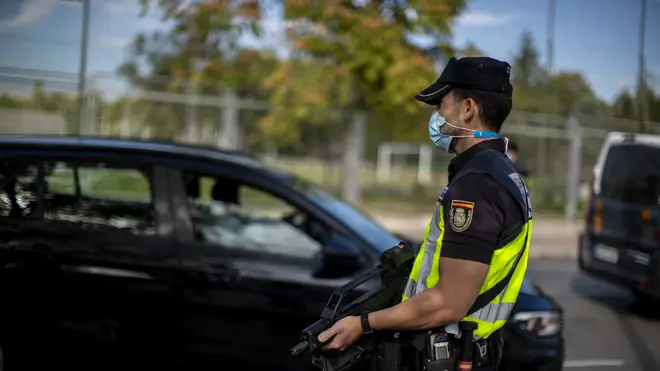 A police officer stands guard at a checkpoint in the Orcasitas neighbourhood in Madrid