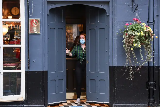 A member of staff closes a door of The Beehive pub in the Grassmarket following last orders at 6pm on October 9, 2020 in Edinburgh, Scotland.