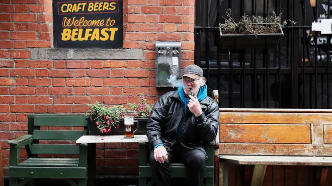 David Legge, from Belfast, enjoys a pint and a pipe outside Bittles Bar in Belfast
