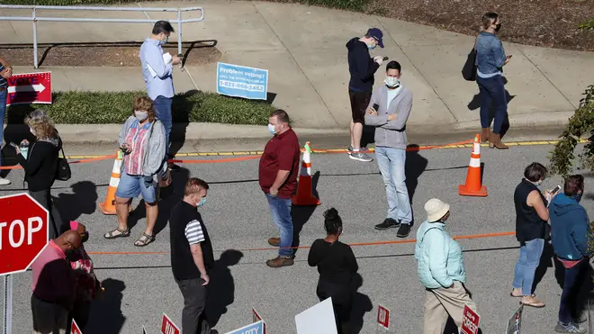 Voters wait in line outside the Herbert C. Young Community Centre in Cary, North Carolina (Ethan Hyman/AP)