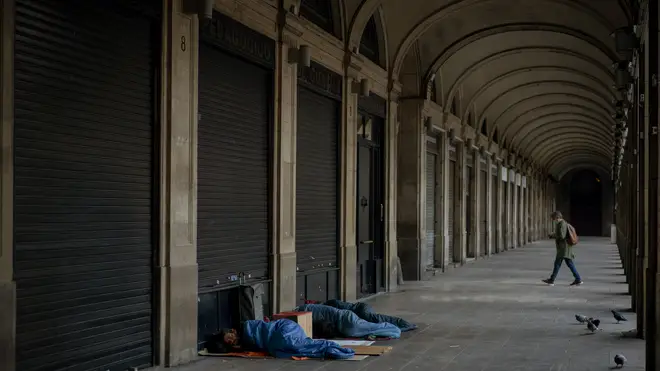 Homeless people sleep on a square where restaurants are closed due to sharpest resurgences of coronavirus in Barcelona, Spain (Emilio Morenatti/AP)