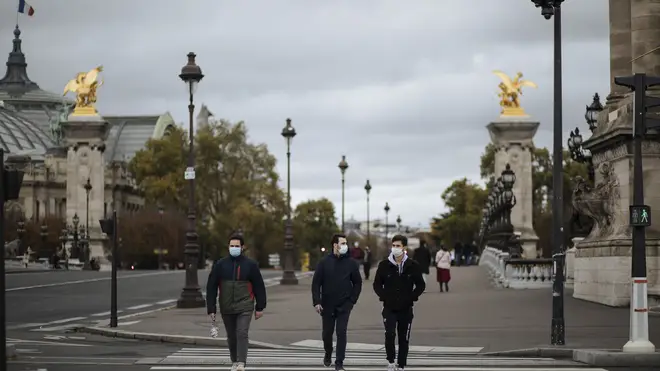 People wearing masks, walk in the Invalides district of Paris (Lewis Joly/AP)