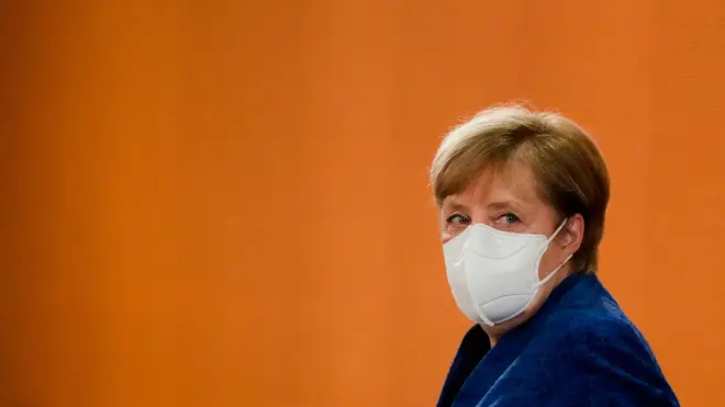German Chancellor Angela Merkel looks sideways wearing a face mask