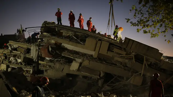 Members of rescue services search for survivors in the debris of a collapsed building in Izmir, Turkey