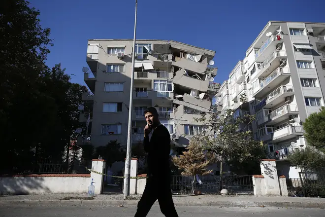 A local resident walks past destroyed buildings in Izmir, Turkey