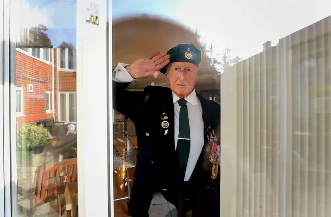 George Bradford, 90, a former Royal Marine stands behind a window at the RBLI home in Aylesford, Kent, during the two minutes silence to pay his respects on Remembrance Sunday.