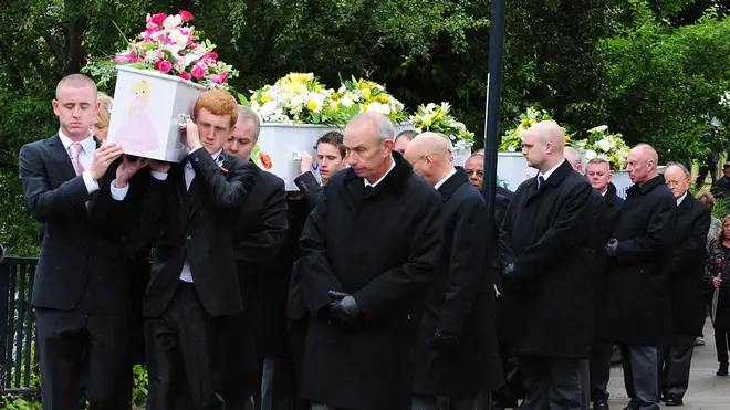 Mourners carry the children's coffins at a joint funeral