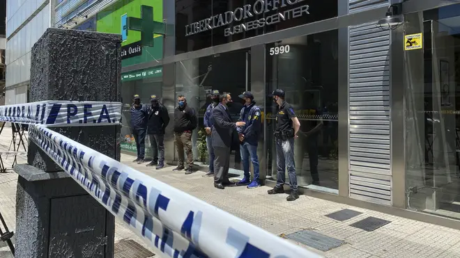 Police guard the entrance to a doctor's practice in Buenos Aires