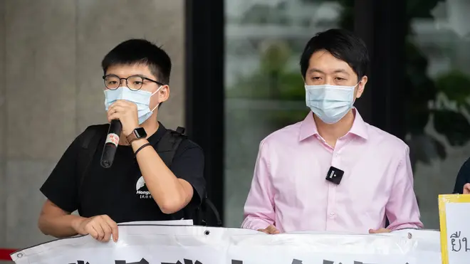 Pro-democracy activist Joshua Wong (left) and lawmaker Ted Hui (right) demonstrate in solidarity with ongoing pro-democracy protests in Thailand