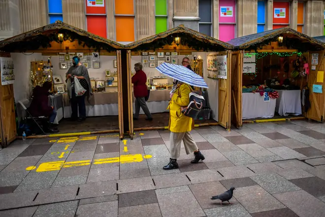 Shoppers walk past Christmas market stalls in the centre of Cardiff