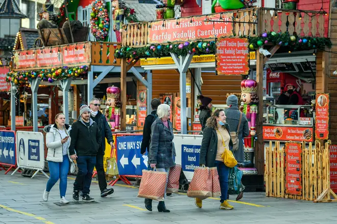 Shoppers pass Christmas market stalls in Cardiff