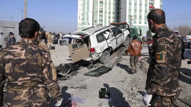 Afghan security personnel inspect the site of a bomb attack in Kabul
