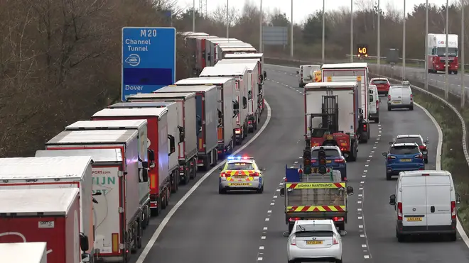 Lorries wait in line along the hard shoulder of the M20 motorway in Kent