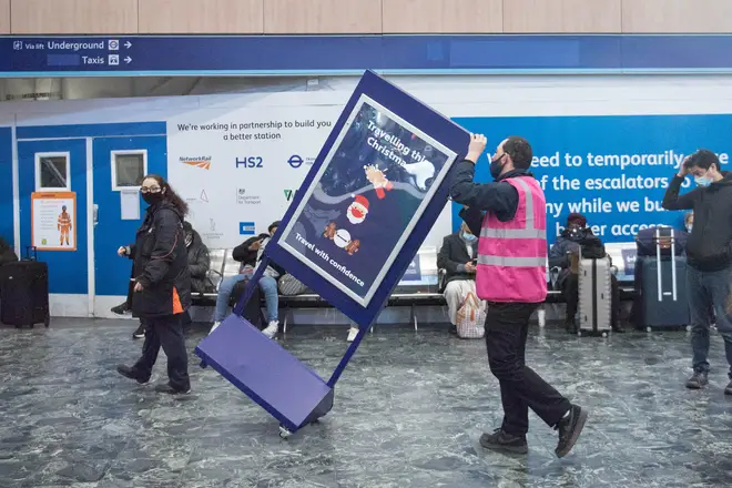 A 'Travelling at Christmas' sign is removed from Euston station, as new laws ban travel from Tier 4 areas such as London.