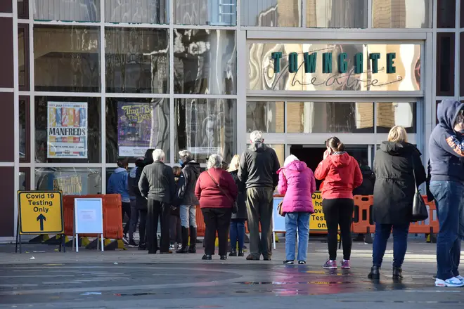 People queue at a COVID-19 testing centre at the Towngate Theatre in Basildon