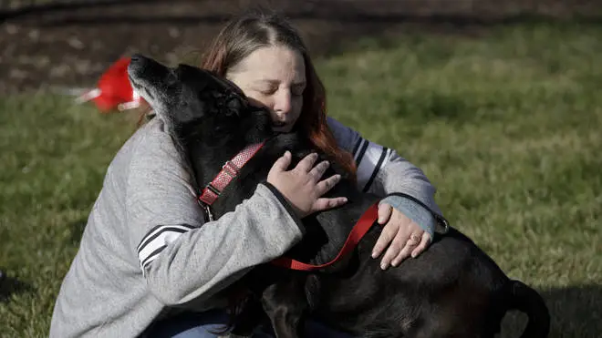 Debra Mejeur hugs her dog Lola after being reunited with her