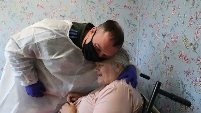 Chris Mills embraces his mother Carol Roberts during a visit at Aspen Hill Village care home