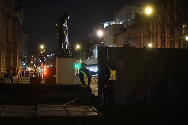 Construction workers put up fencing around the statues in Parliament Square, London, ahead of New Year's Eve