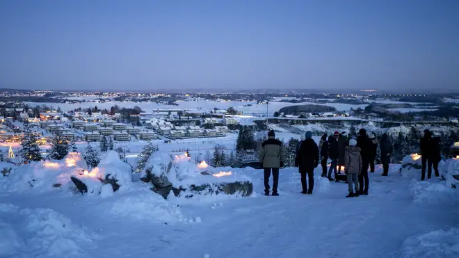 People light candles near the landslide area in the village of Ask in Gjerdrum, Norway (Cornelius Poppe/AP)