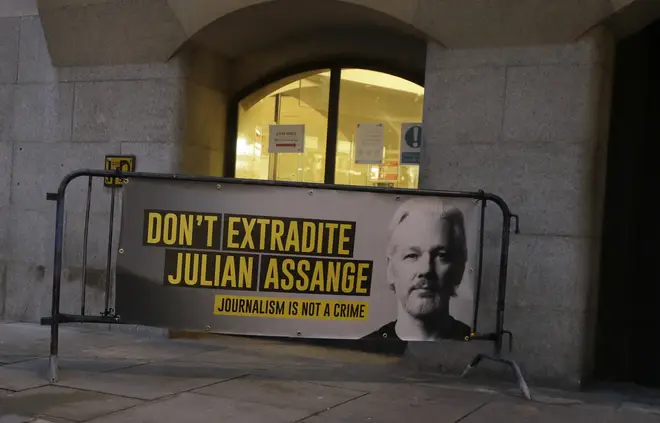 Julian Assange supporters placed a placard on a barrier outside the Old Bailey