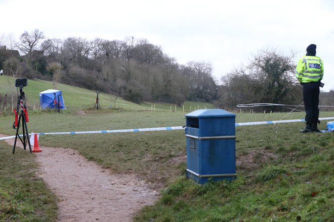A police officer watches as a forensic tent is set up in Bugs Bottom field