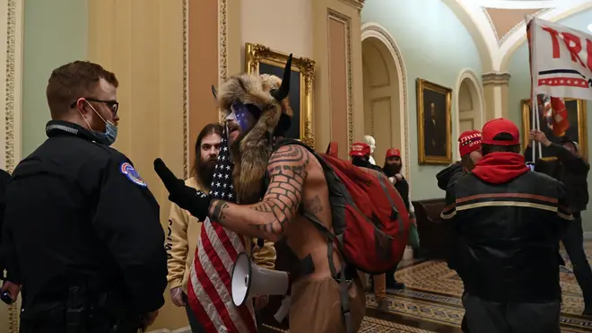 A US Capitol police officer wears agas mask as supporters of US President Donald Trump enter the Capitol