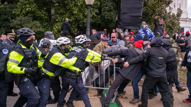 Supporters of President Trump attempt to wrestle a barrier away from Capitol Police in Washington