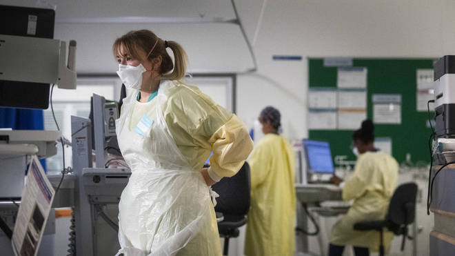 A nurse adjusts her PPE in the Intensive Care Unit
