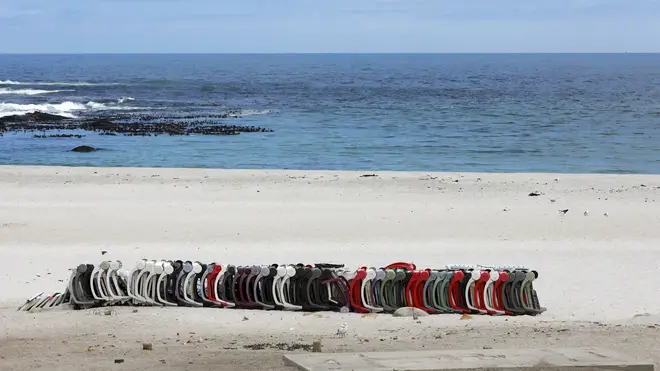 Stacked beach chairs lay on the closed beach in Camps Bay, Cape Town (Nardus Engelbrecht/AP)