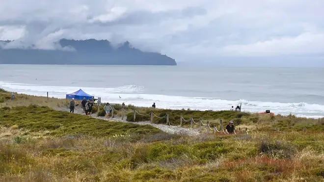 People walk near a beach following a shark attack at Bowentown near Waihi in New Zealand