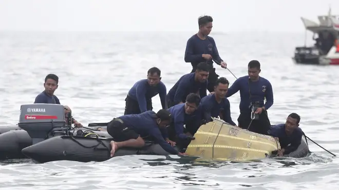 Divers pull wreckage from the passenger plane out of the Java Sea