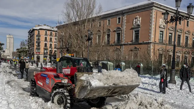 A plough clears snow in central Madrid (Manu Fernandez/AP)