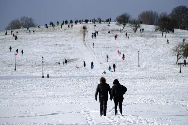 File photo: A couple walk up Primrose Hill after a snow blizzard in London during the last Beast from the East