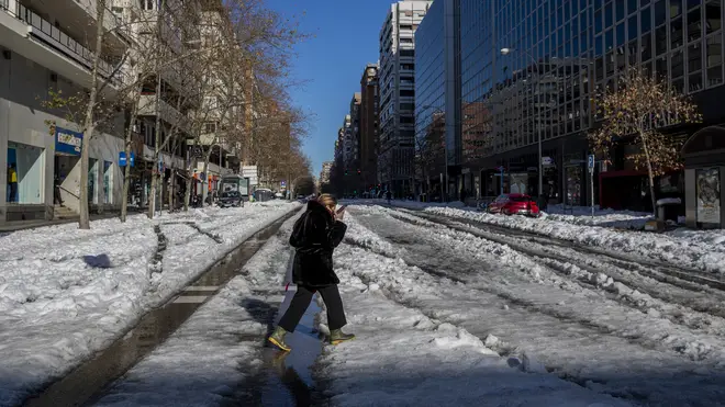 A woman walks through the snow in Madrid, Spain