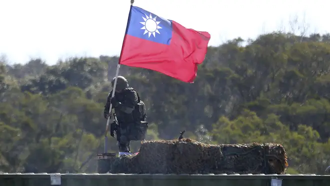 A soldier holds a Taiwan national flag during a military exercise in Hsinchu County, northern Taiwan (Chiang Ying-ying/AP)