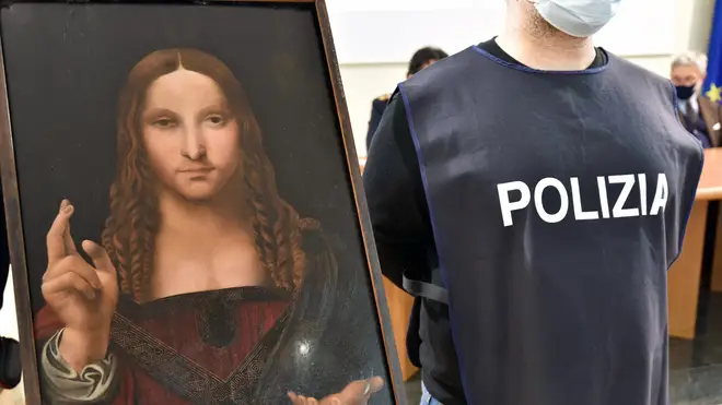An Italian police officer stands by a copy of the Salvator Mundi in Naples
