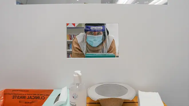 A clinician looks through a window at a lateral flow testing centre in Ealing Library, London