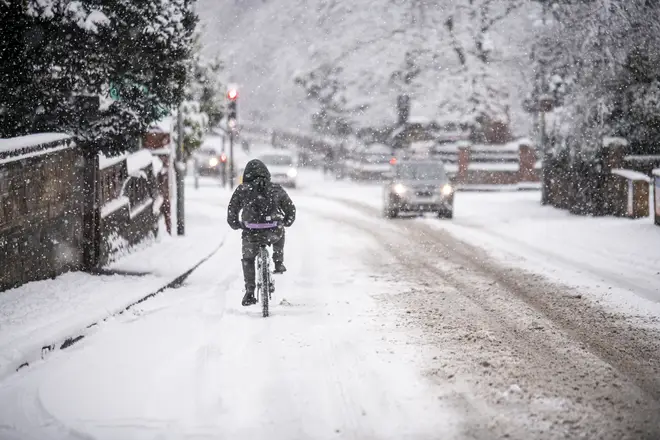A man cycles through heavy snow in Worcester, Worcestershire on Sunday.