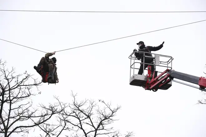 Enforcement officers used arial platforms to approach the protesters, one of whom was attached to a zip line between two trees.