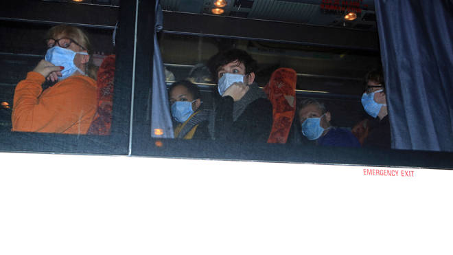 Passengersfrom a cruise ship hit by the coronavirus in Yokohama, Japan, arrive by coach at Arrowe Park Hospital on Merseyside