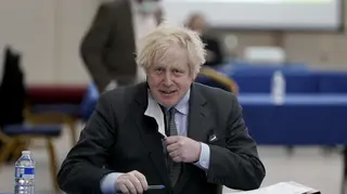 Britain's Prime Minister Boris Johnson sits to prepare for a visit at a COVID-19 vaccination centre in Batley, West Yorkshire