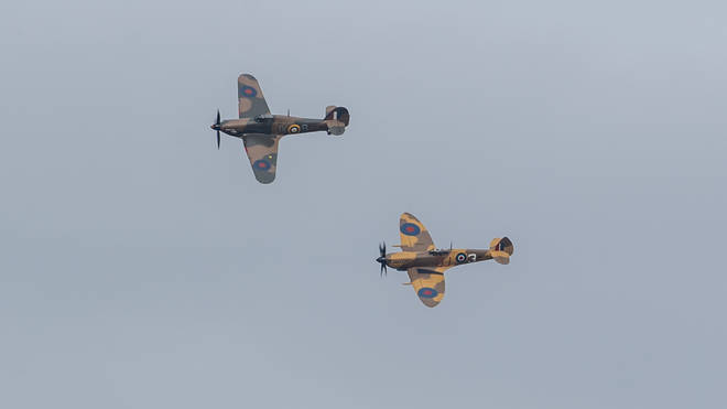 A Spitfire and Hurricane pass over the home of Capt Sir Tom on his 100th birthday