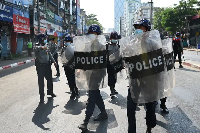 Riot police block a street as protesters gather for a demonstration against the military coup in Yangon