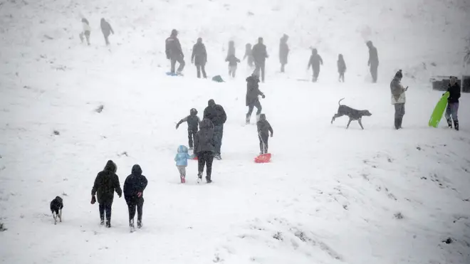 People enjoy the fresh snow in Wye National Nature Reserve near Ashford in Kent