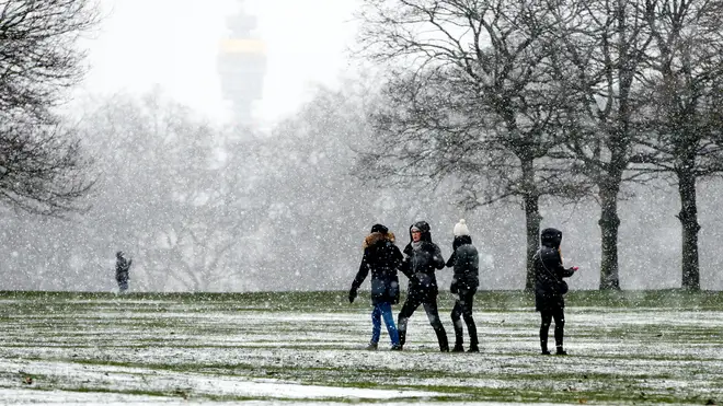 People walk through Storm Darcy snowfall in Hyde Park in London