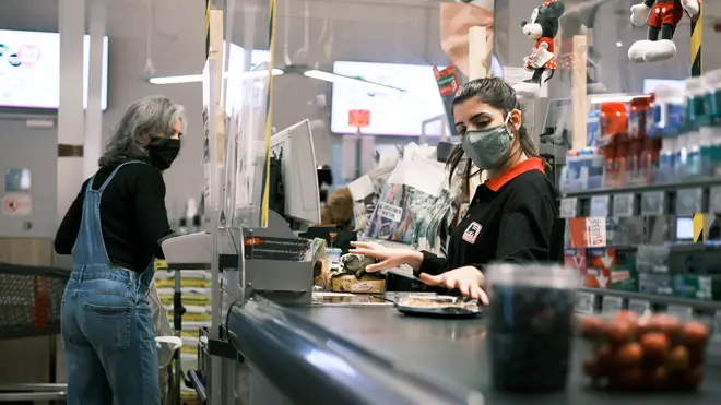 A staff member wearing a face mask works at a supermarket in Brussels