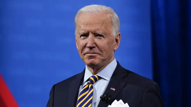 President Joe Biden stands on stage during a break in a televised town hall event