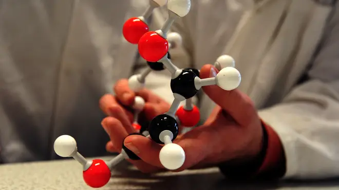 A scientist holds a molecular model