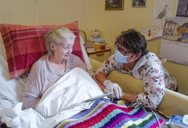 File photo: Care home resident Dot Hendy holds her daughter Louise's hand for the first time since March after Louise successfully passed a Rapid Covid-19 Test
